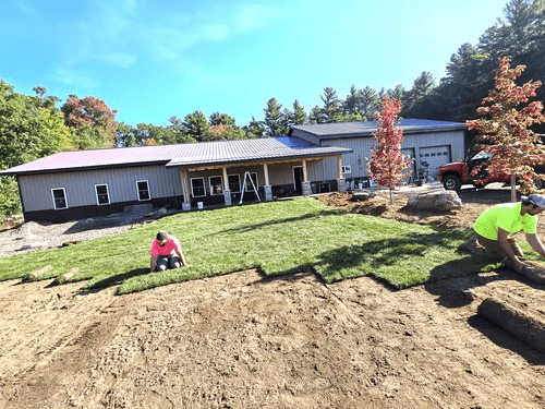 Professional landscapers laying fresh sod to transform a backyard in Wisconsin.